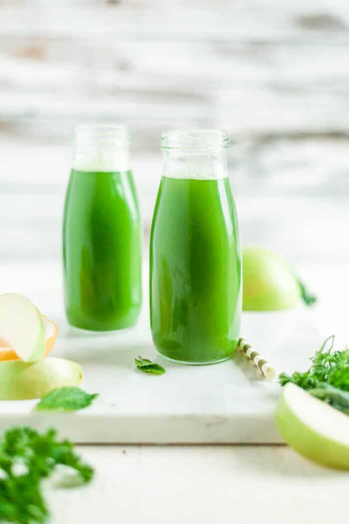 two glasses of green juice on a serving tray