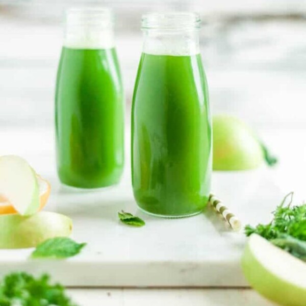 two glasses of green juice in milk jars