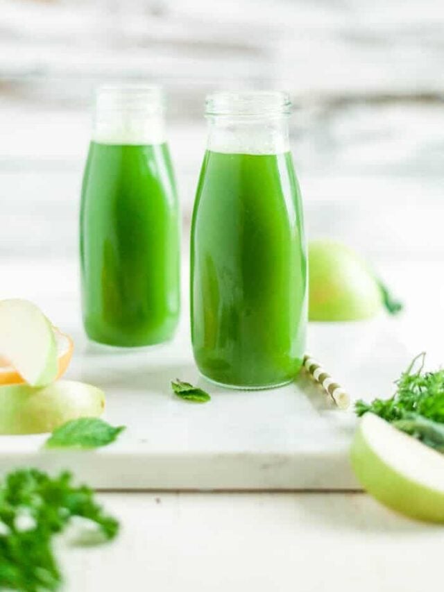 two glasses of green juice in milk jars