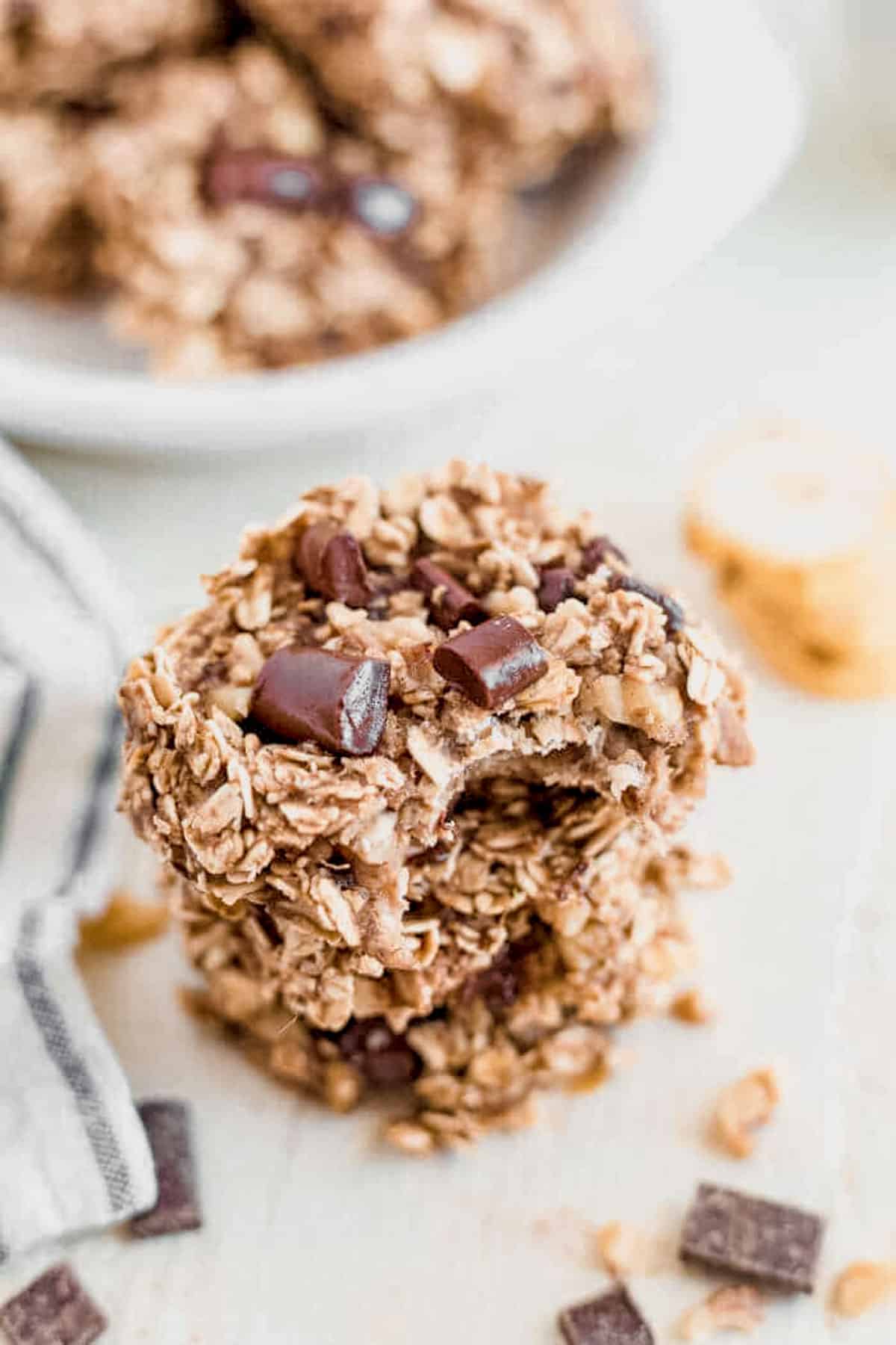 a bite taken out of a banana oatmeal chocolate chip cookie on a countertop