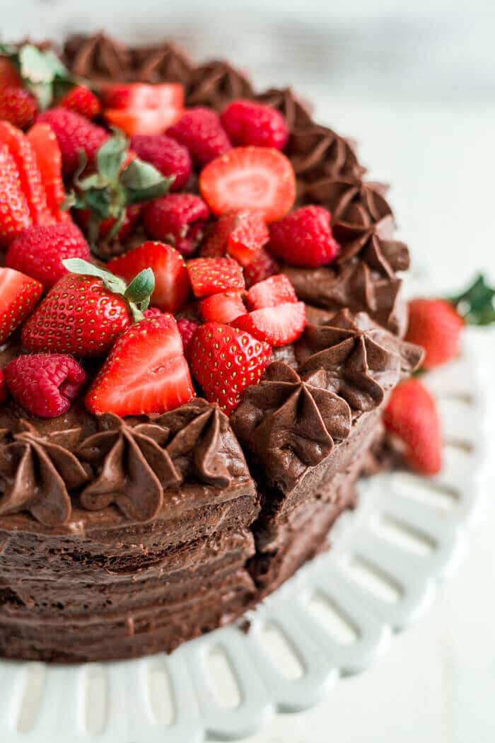 strawberries and raspberries on top of a paleo chocolate cake