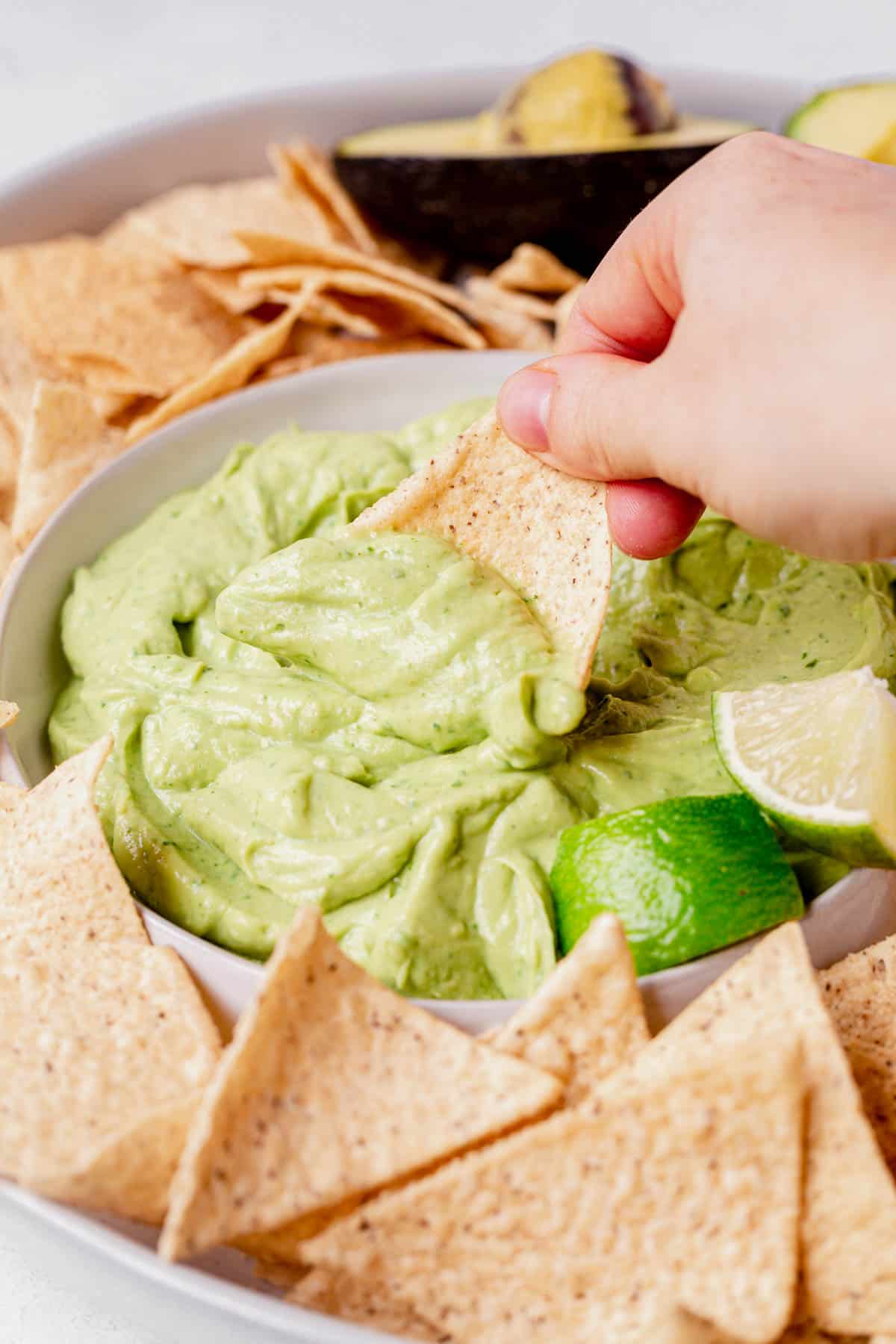 a chip scooping out avocado dip