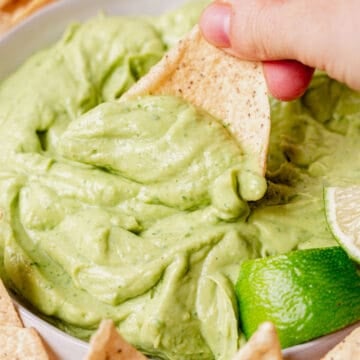 scooping avocado dip onto a chip
