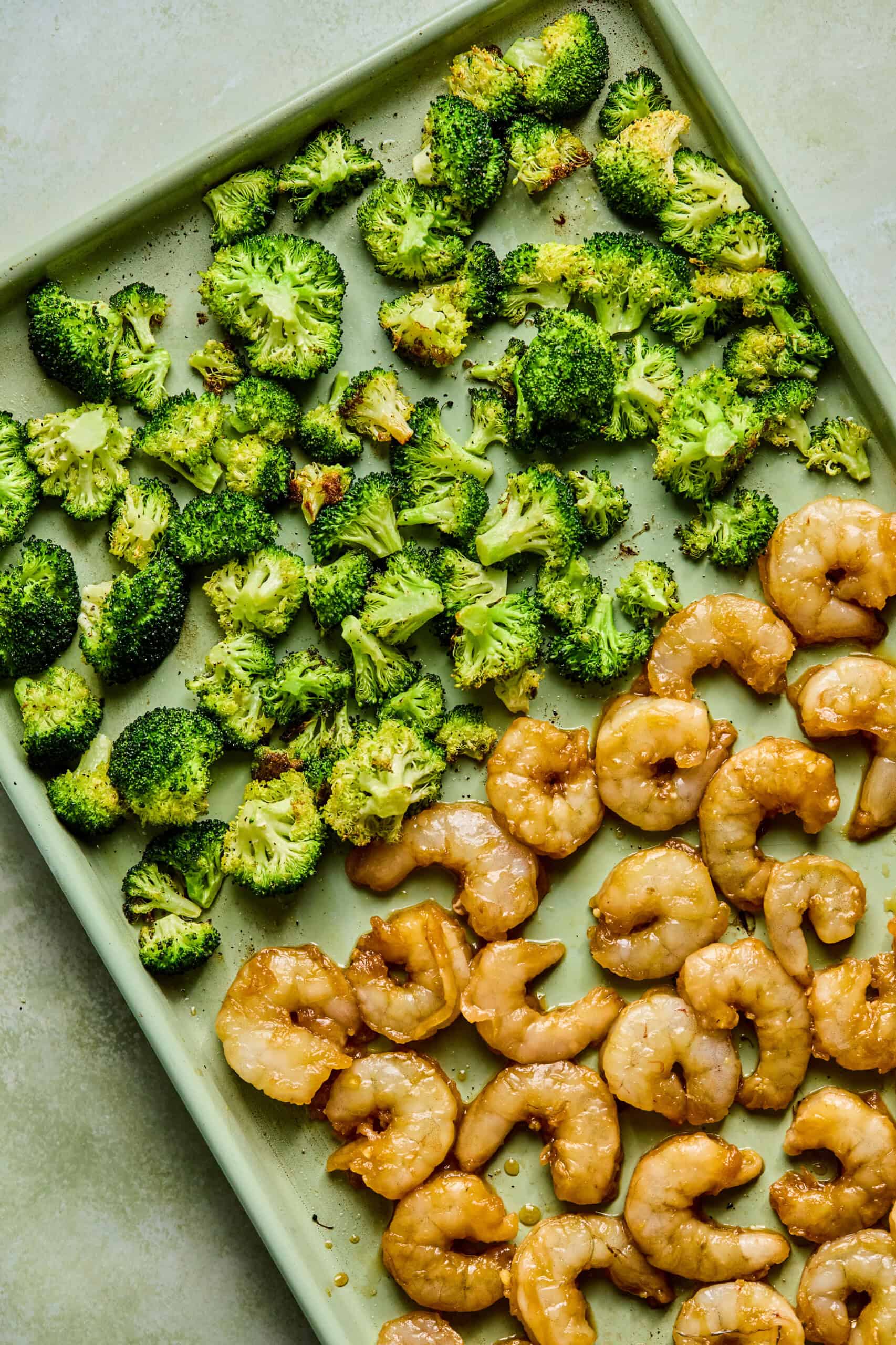 marinated shrimp and roasted broccoli on a sheet pan.
