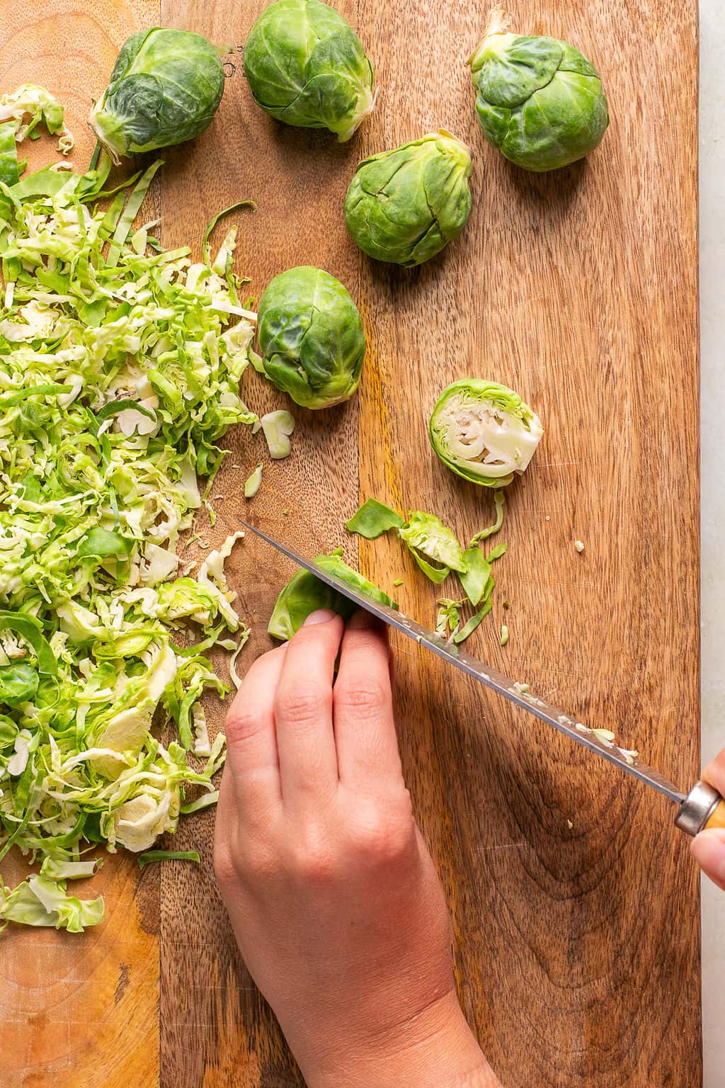 shredding brussels sprouts on a cutting board