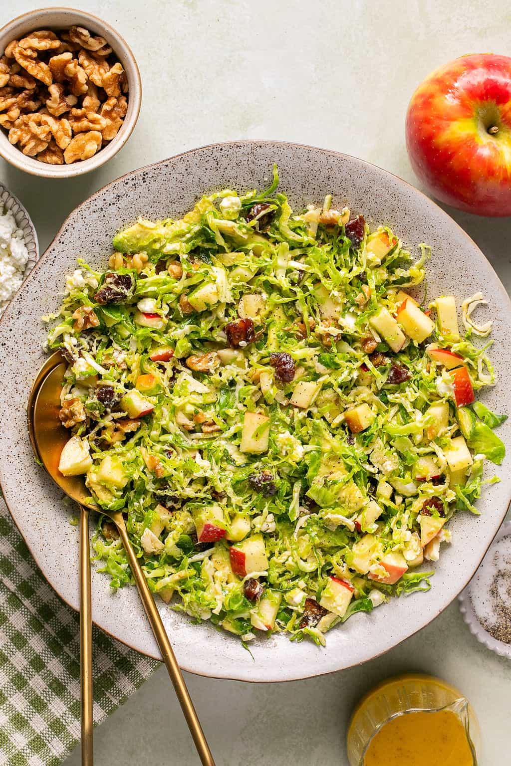 shaved brussels sprout salad in a bowl with serving spoons