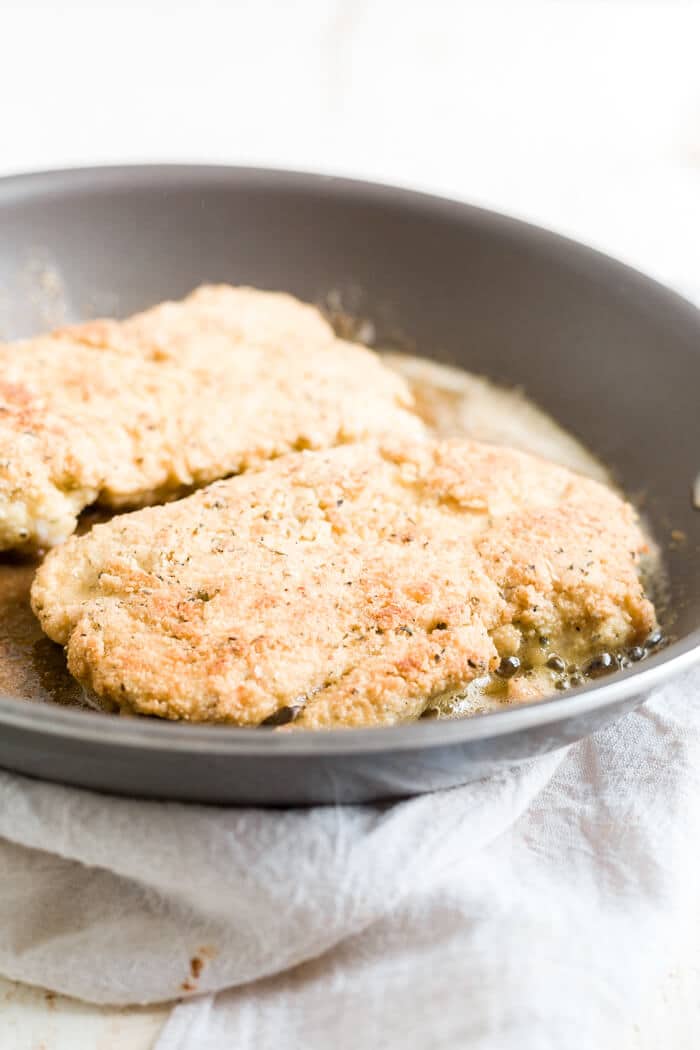 breaded chicken cooking in a pan