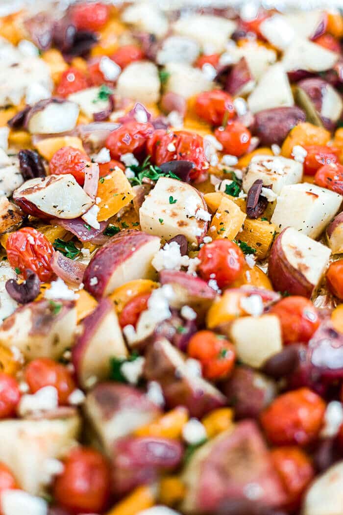 roasted red potatoes, tomatoes, peppers and onion with greek chicken marinade on a sheet pan