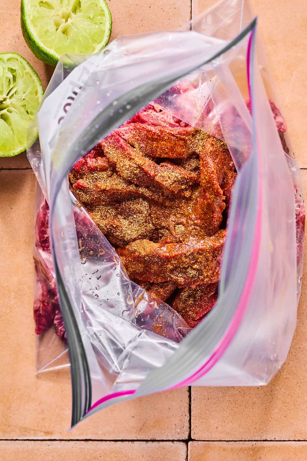 sliced flank steak in a freezer bag coated in fajita seasoning.