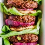 teriyaki burger, grilled pineapple, red onion and lettuce stacked on a plate