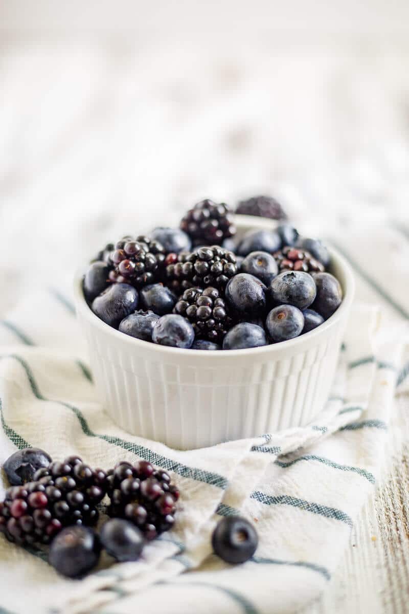 blackberries and blueberries in a white dish