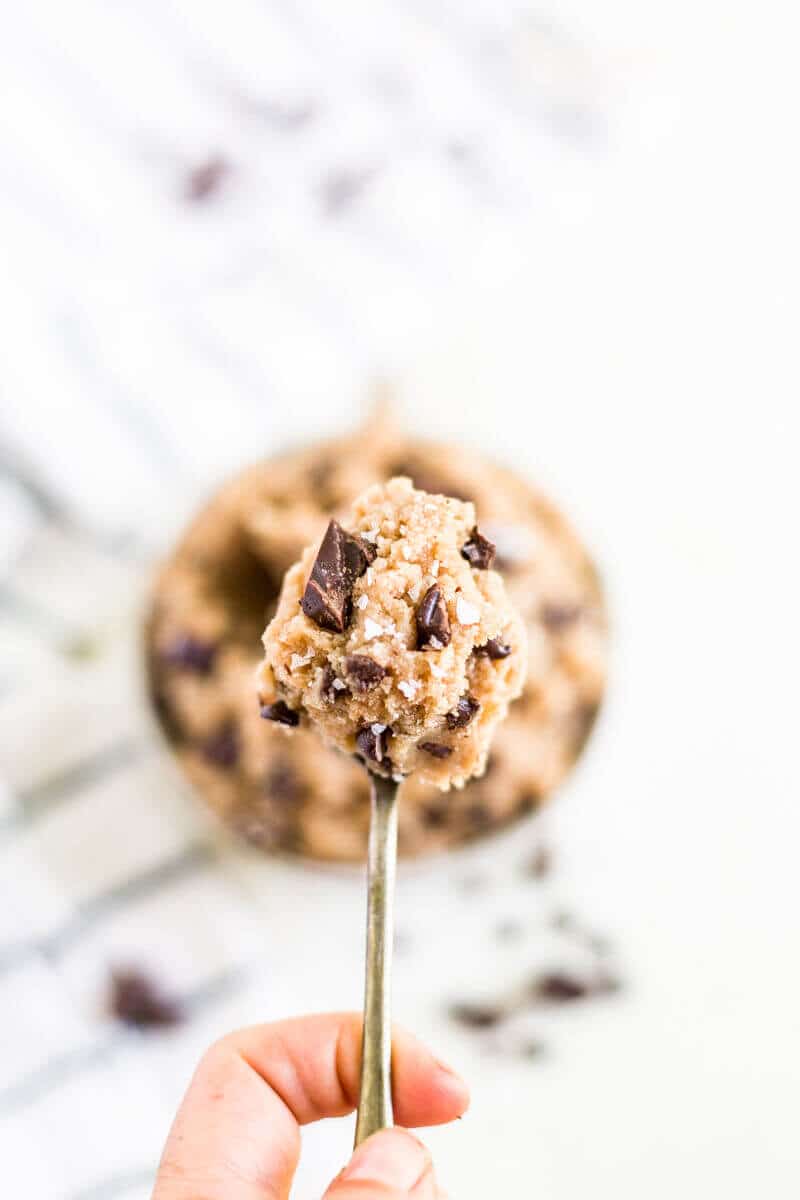 healthy edible cookie dough on a spoon topping with flaky sea salt