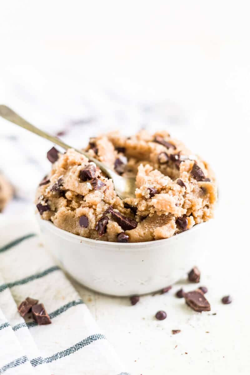 healthy cookie dough dip in a white bowl with a spoon scooping some out