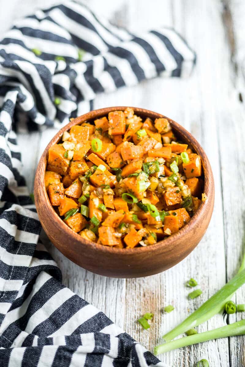 sweet potato salad in a wooden bowl next to a napkin