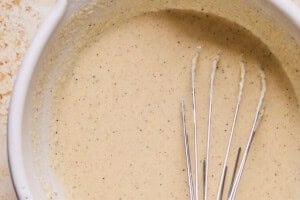 whisked orange cauliflower batter in a mixing bowl.