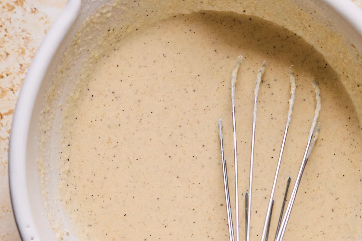 whisked orange cauliflower batter in a mixing bowl.