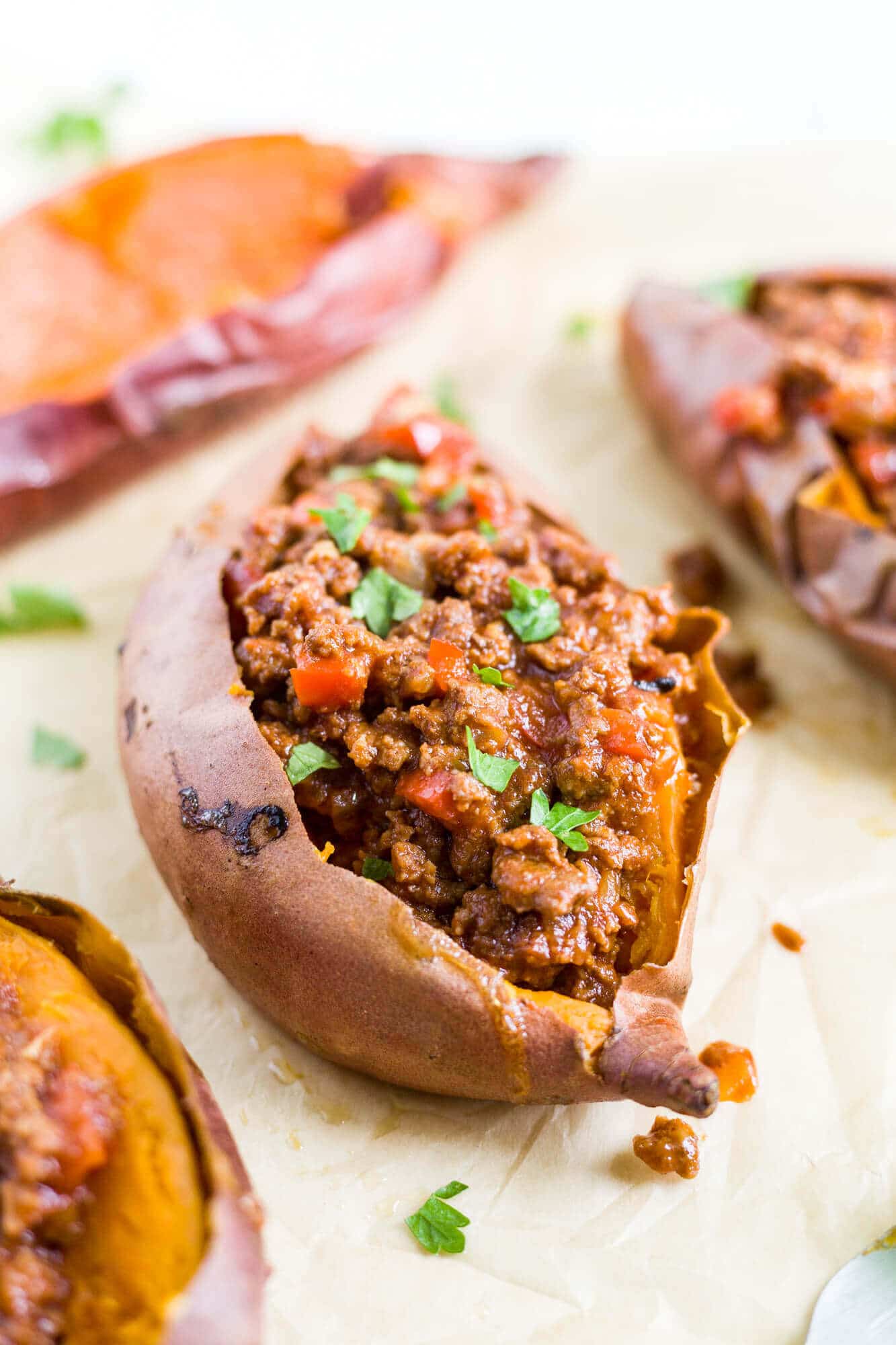 slow cooker healthy sloppy joes stuffed inside a sweet potato topped with parsley