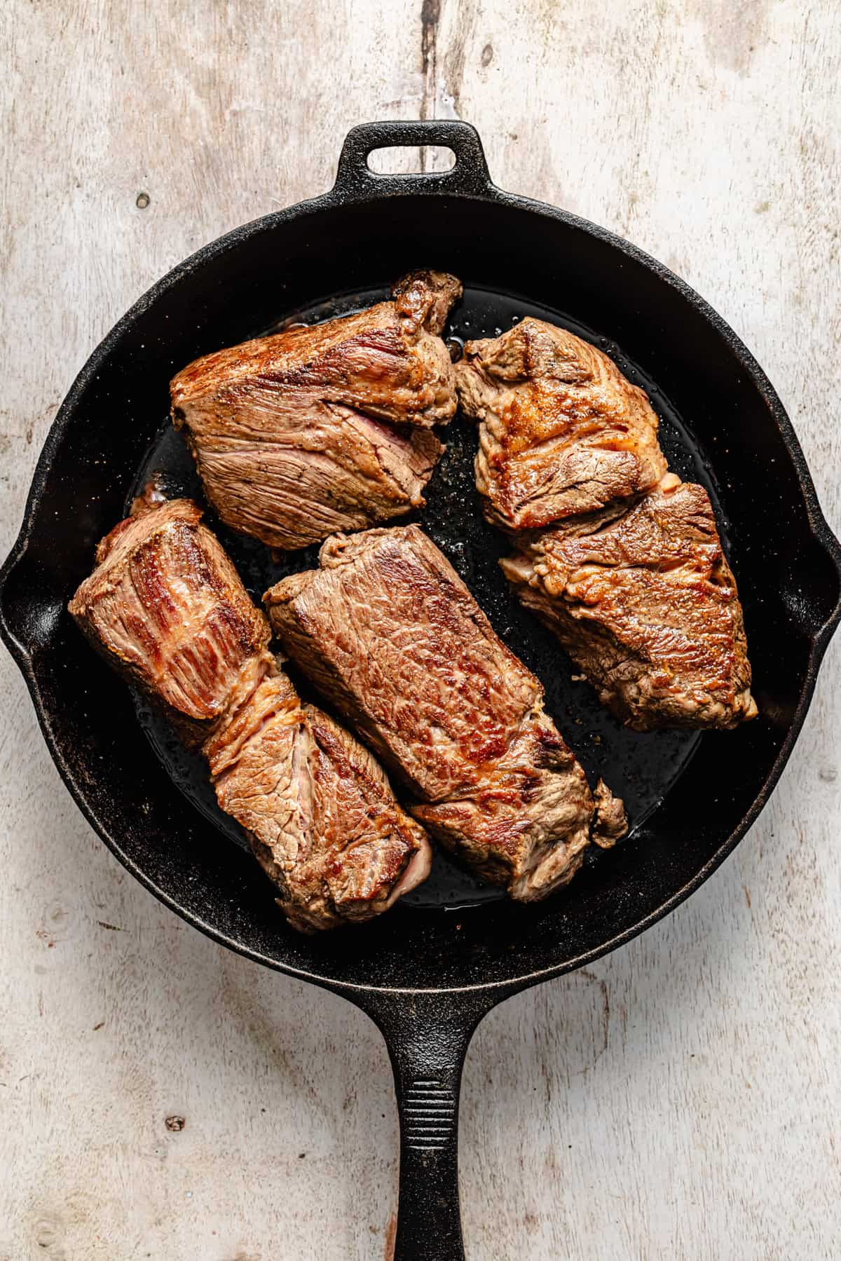 seared chuck roast in a cast iron skillet.