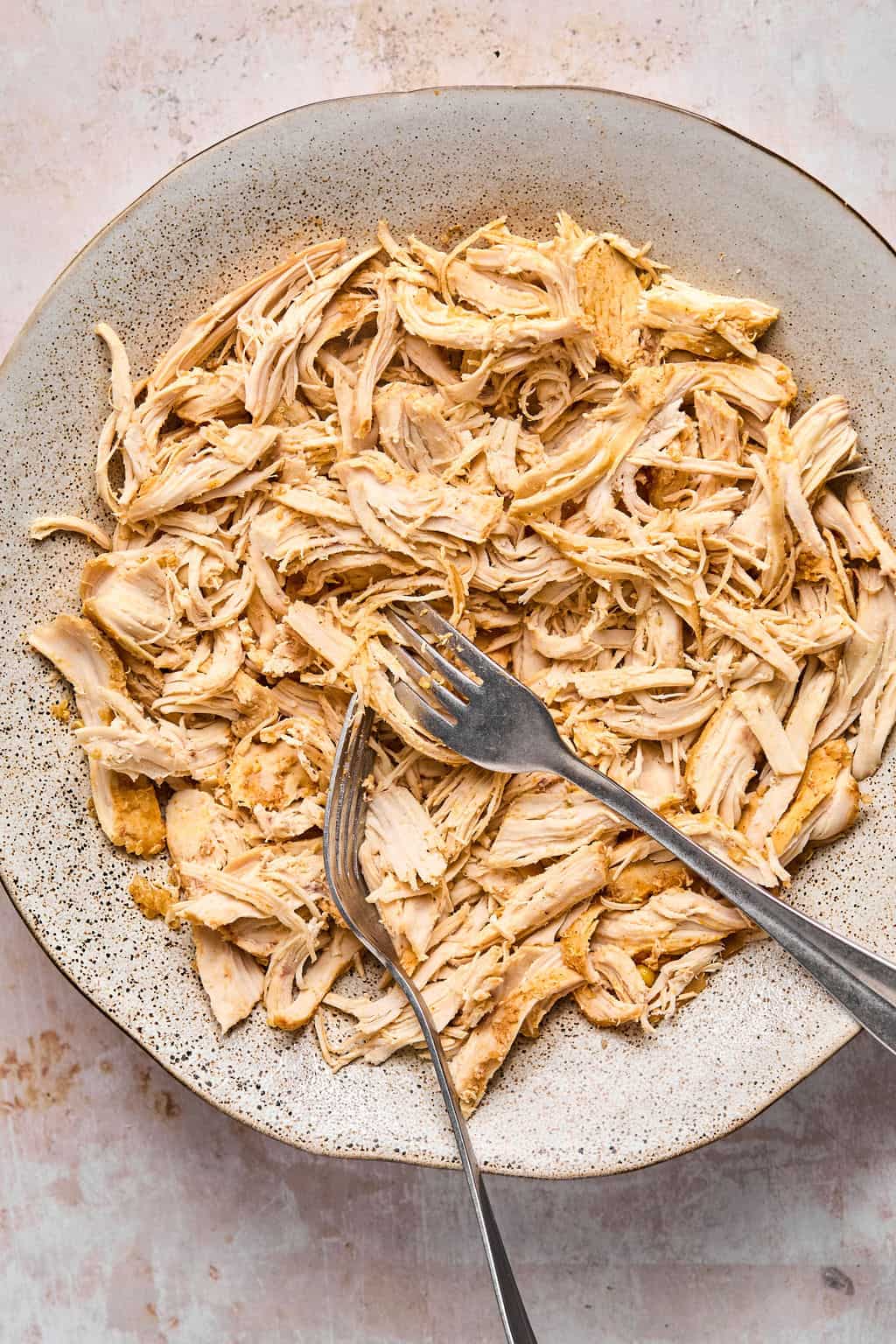 shredded chicken in a bowl with 2 forks.