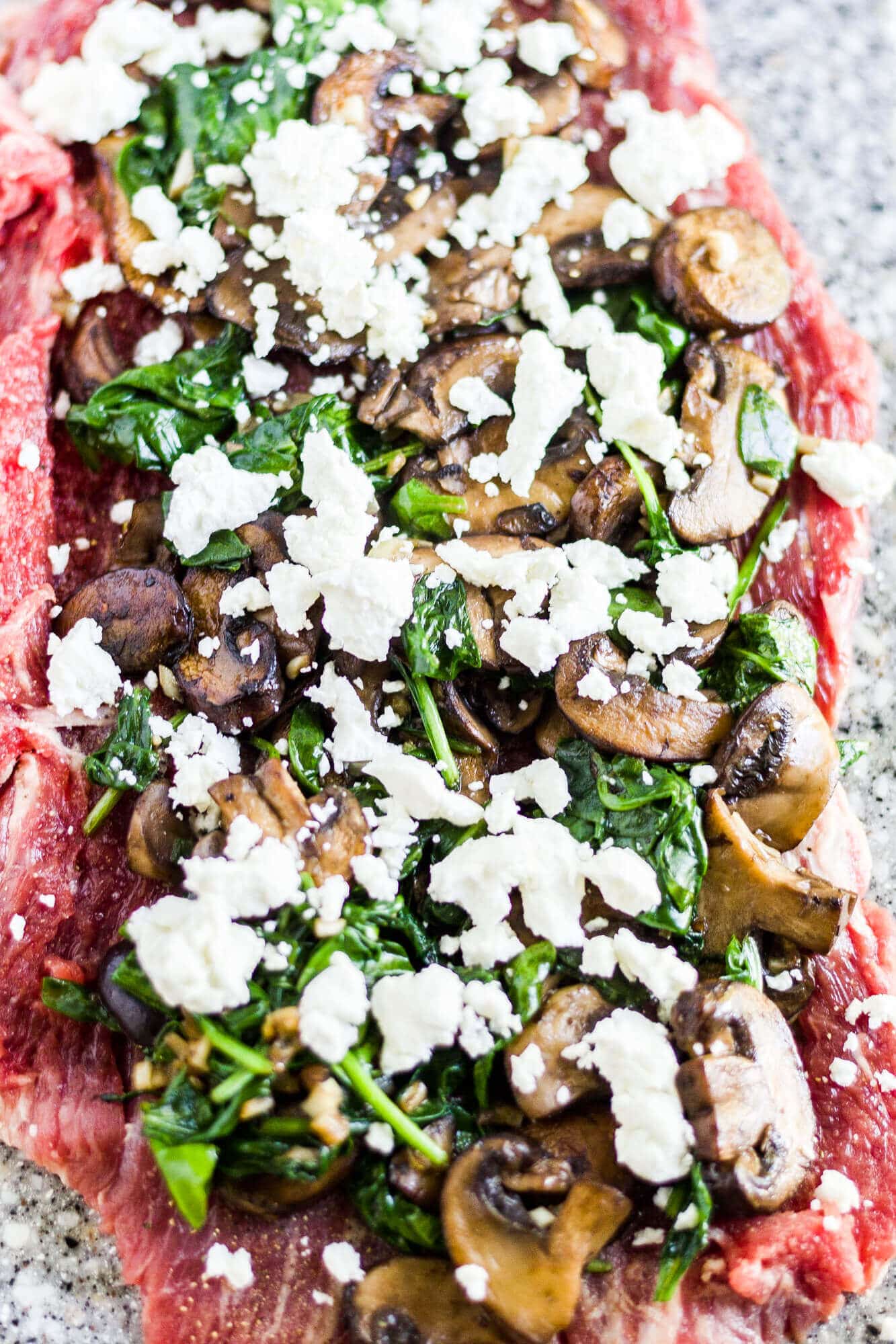 satueed mushrooms and spinach on top of flank steak with goat cheese