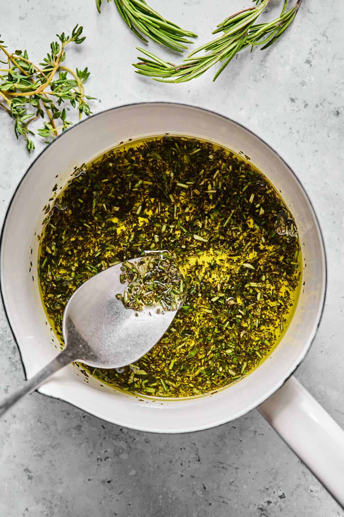 olive oil, fresh rosemary, and fresh thyme infusing in a small saucepan.