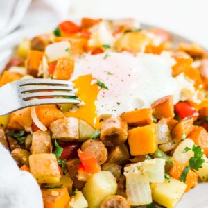 healthy sweet potato breakfast hash on a plate with an over easy egg