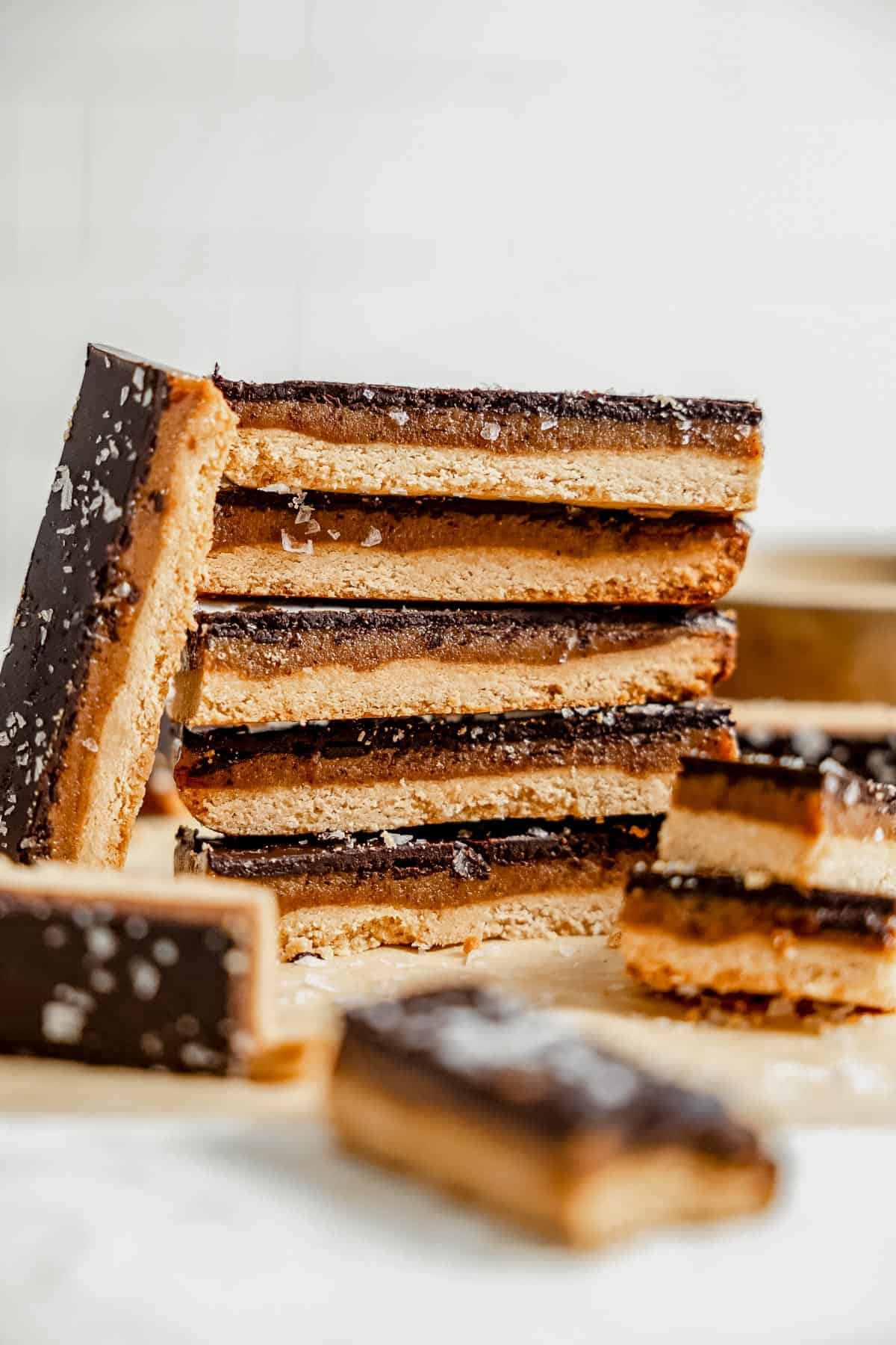 a stack of healthy homemade twix bars on a piece of parchment paper.