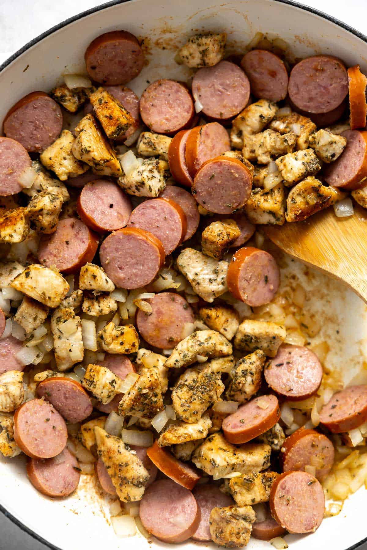 cajun chicken and sausage cooking in a skillet.