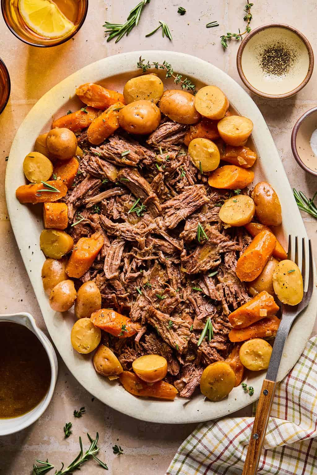 instant pot pot roast on a serving platter with potatoes and carrots around it.