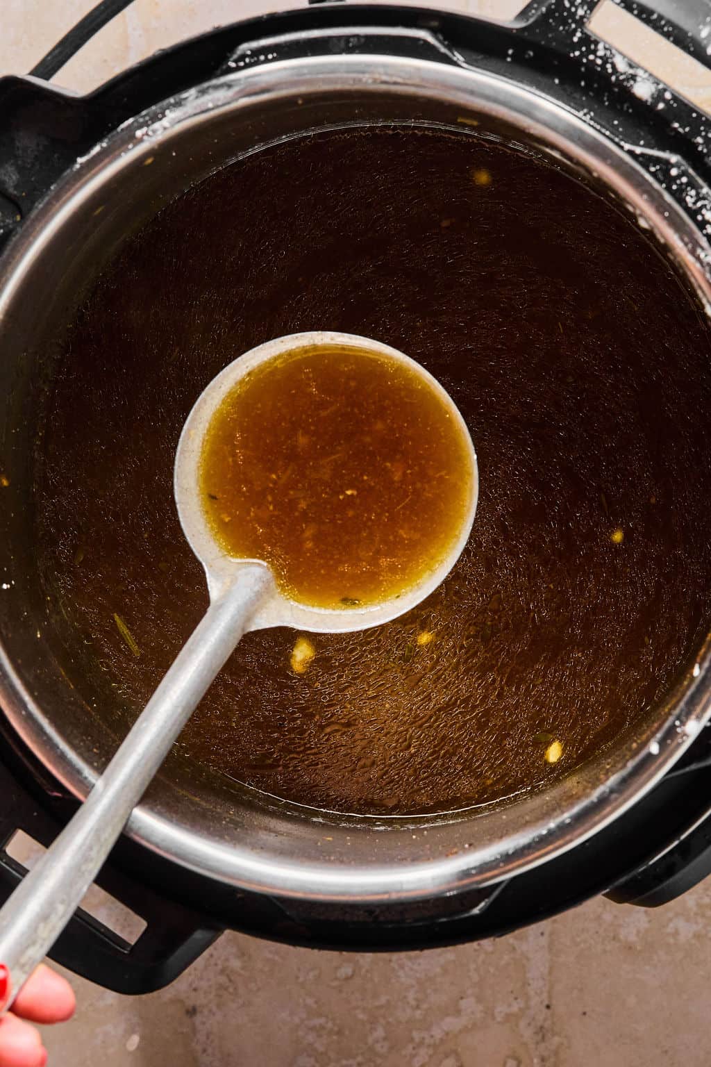 scooping out the gravy for instant pot pot roast.