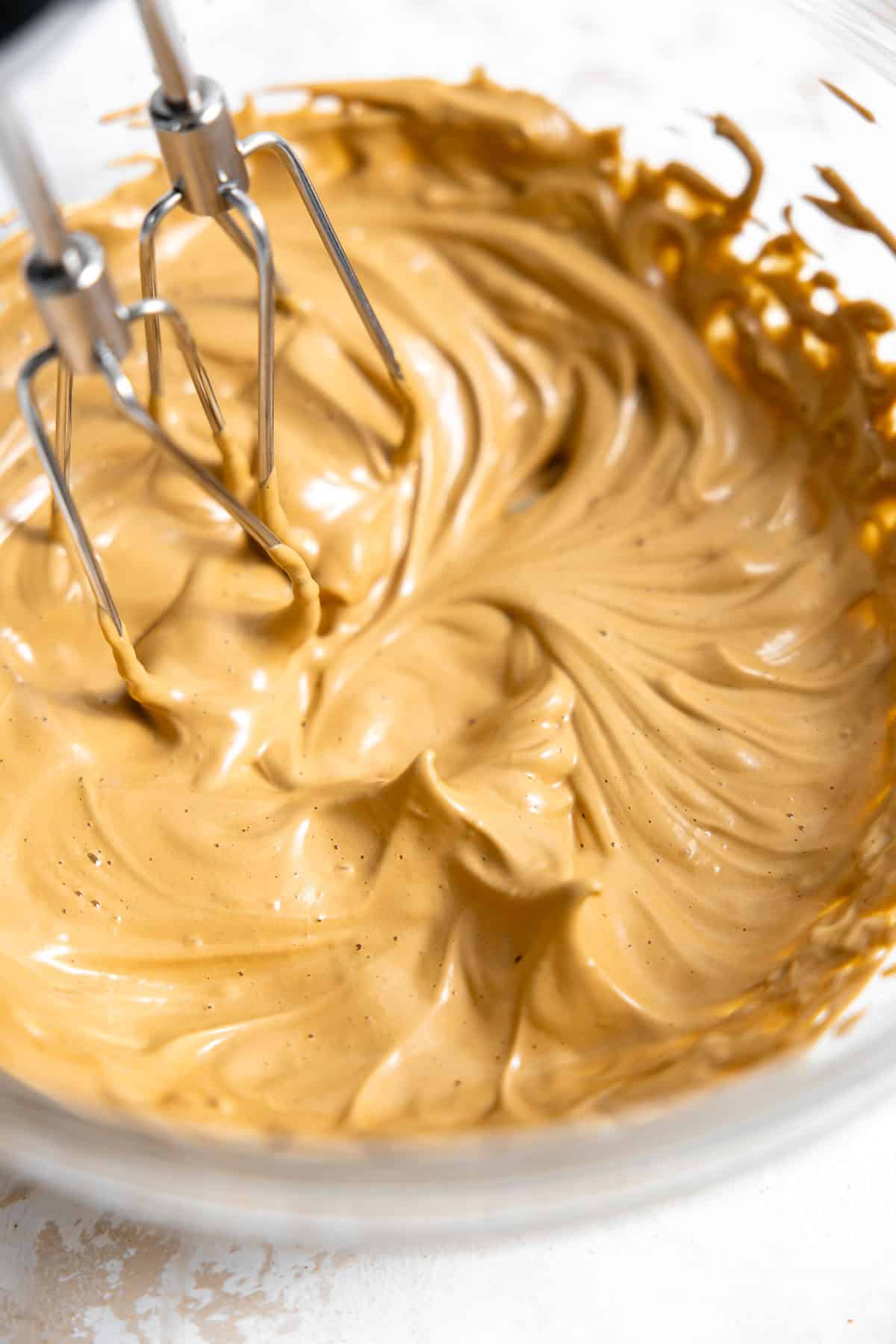 whipping instant coffee in a bowl with an electric mixer.