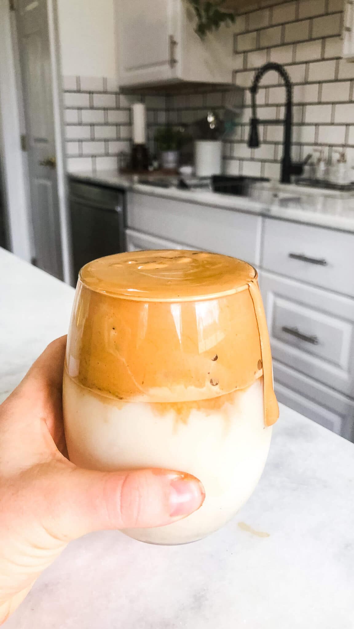 dalgona iced coffee in a glass in a kitchen