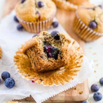 blueberry lactation muffin with the muffin liner unwrapped and a bite taken out of it