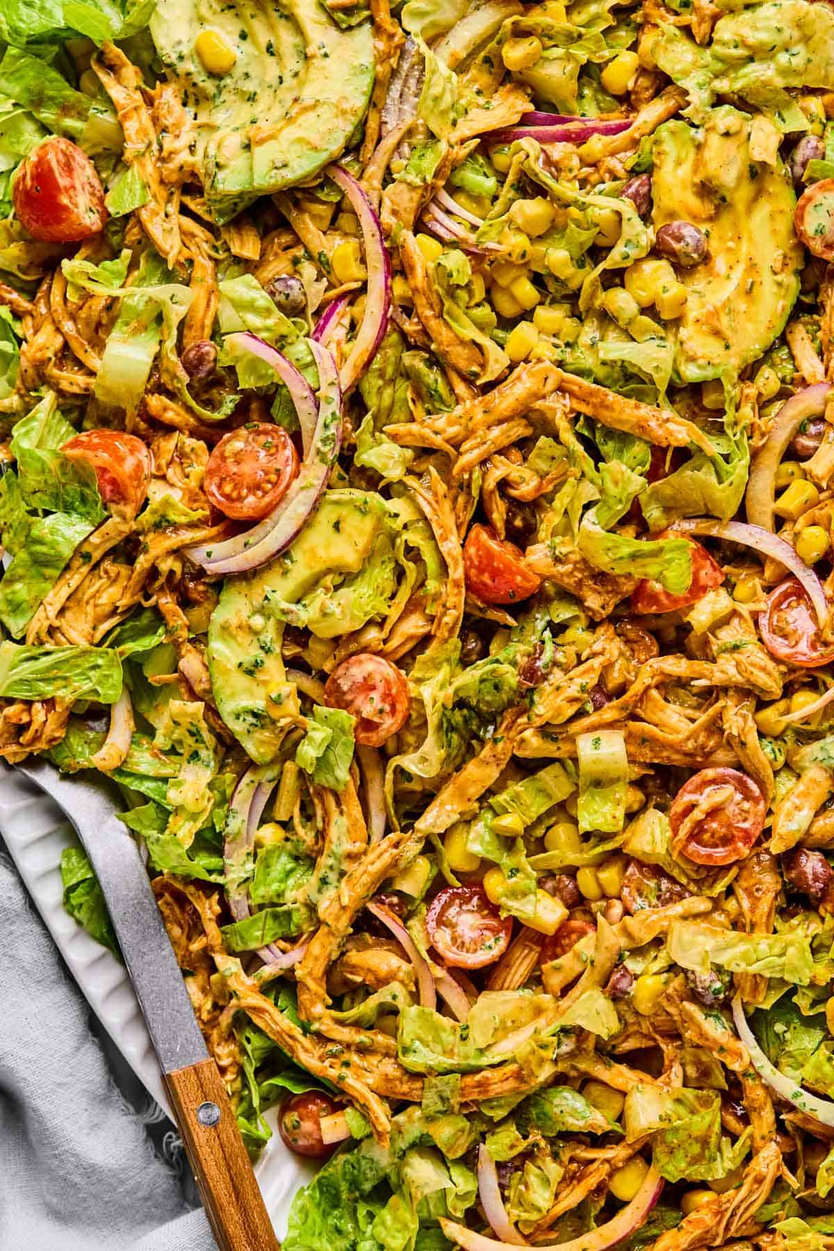 barbeque chicken salad mixed together on a plate with dressing