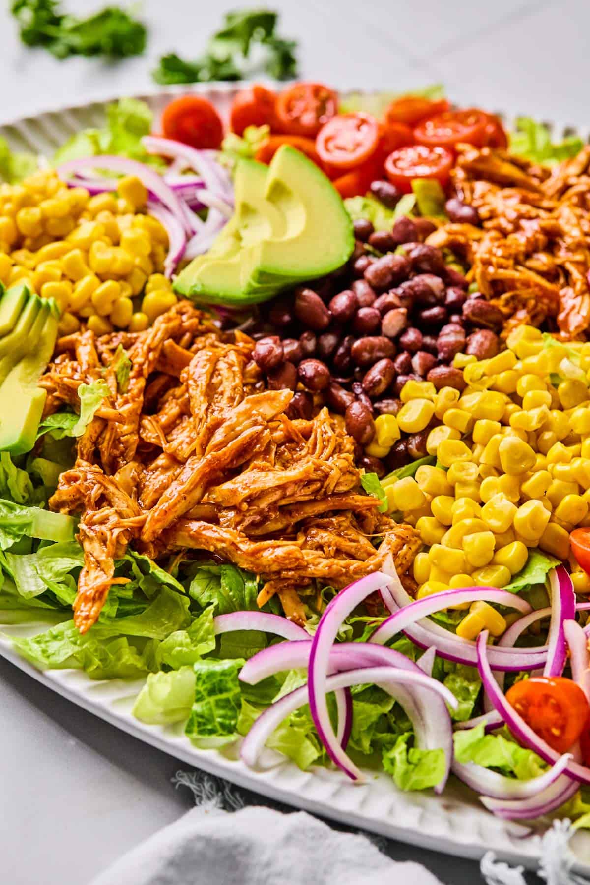 ingredients for bbq chicken salad added to a bowl before combining