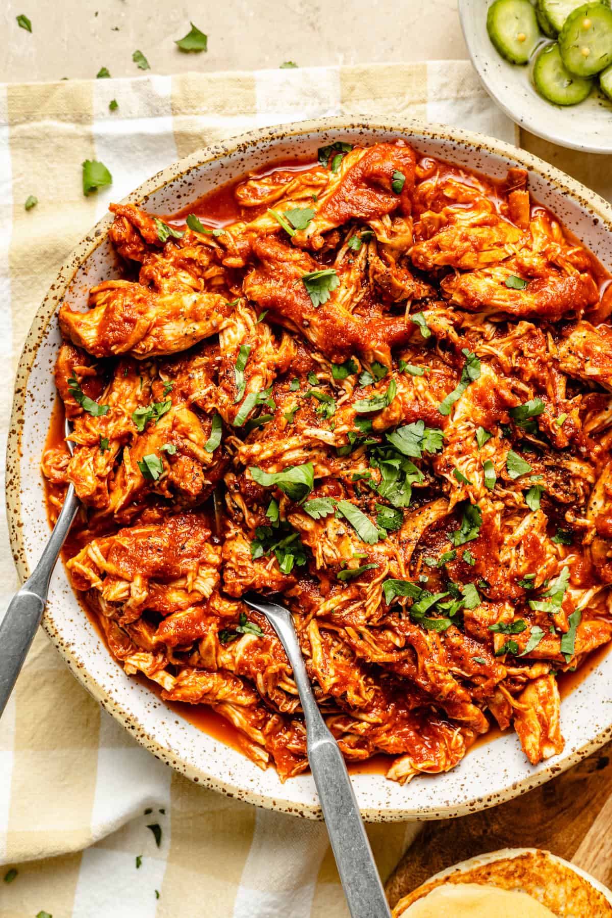 slow cooker bbq pulled chicken in a bowl with two forks.