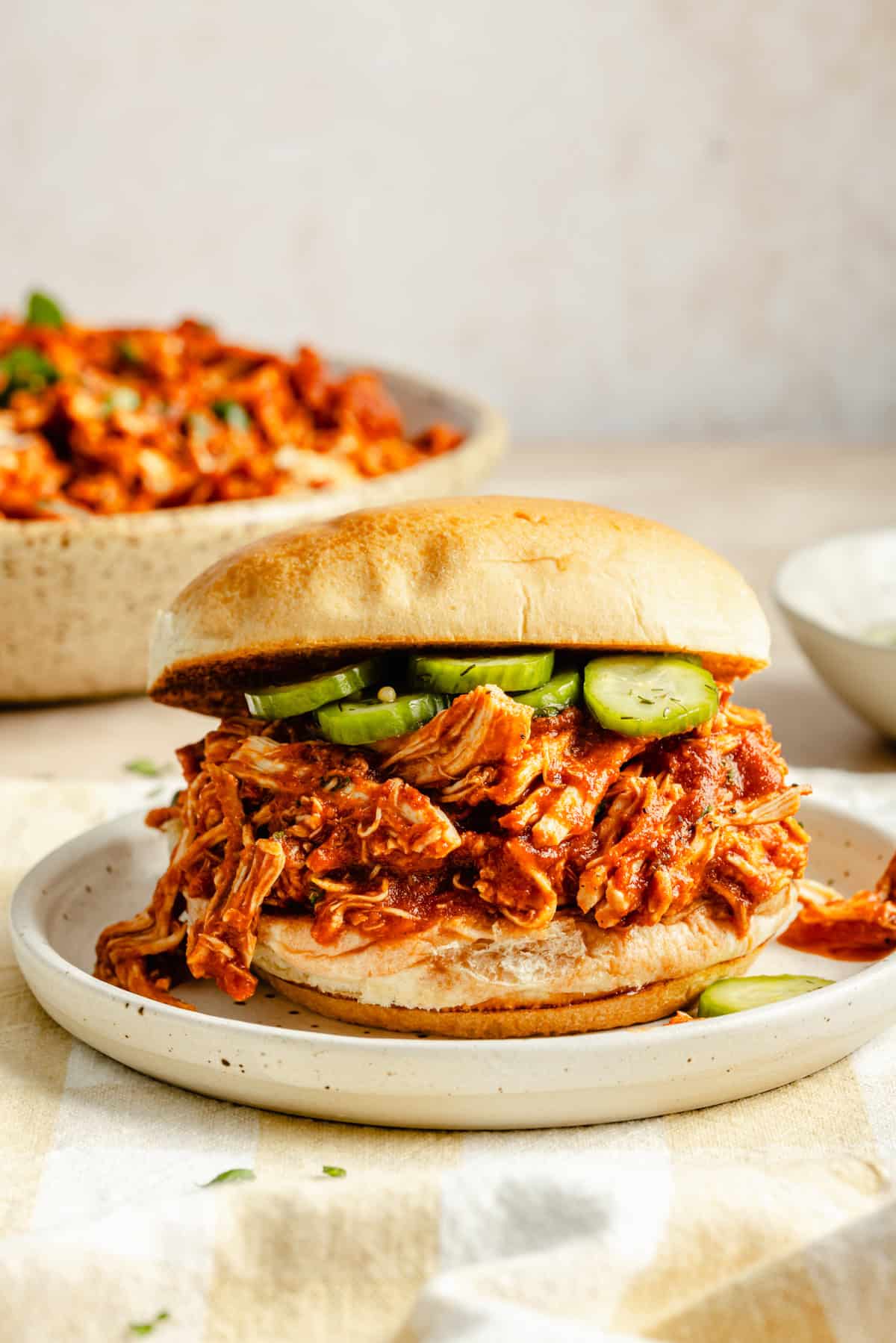 crock pot bbq chicken sandwich on a bun with pickles.