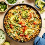 mexican beef and rice skillet topped with avocado, tomato, cheese, and cilantro.