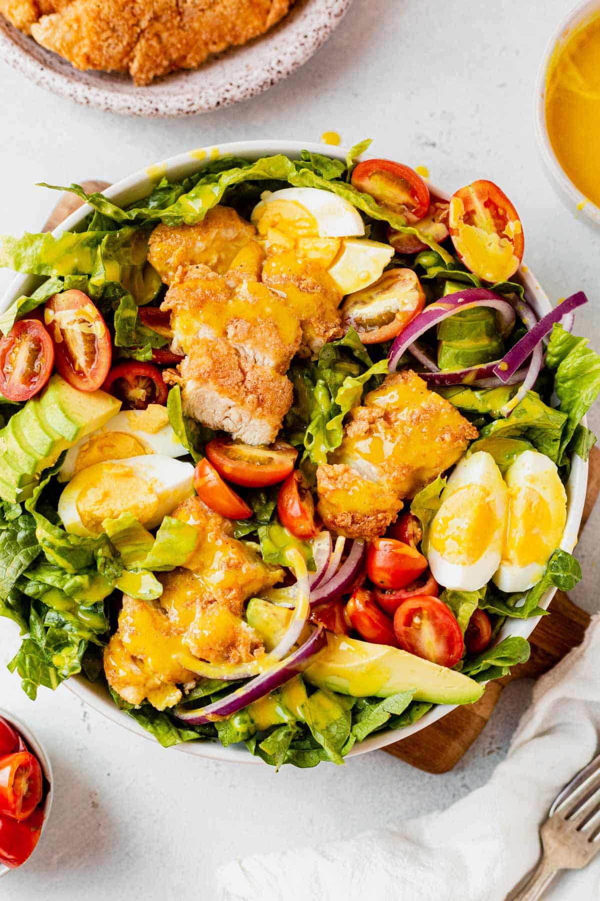 a bowl of crispy chicken salad with honey mustard dressing