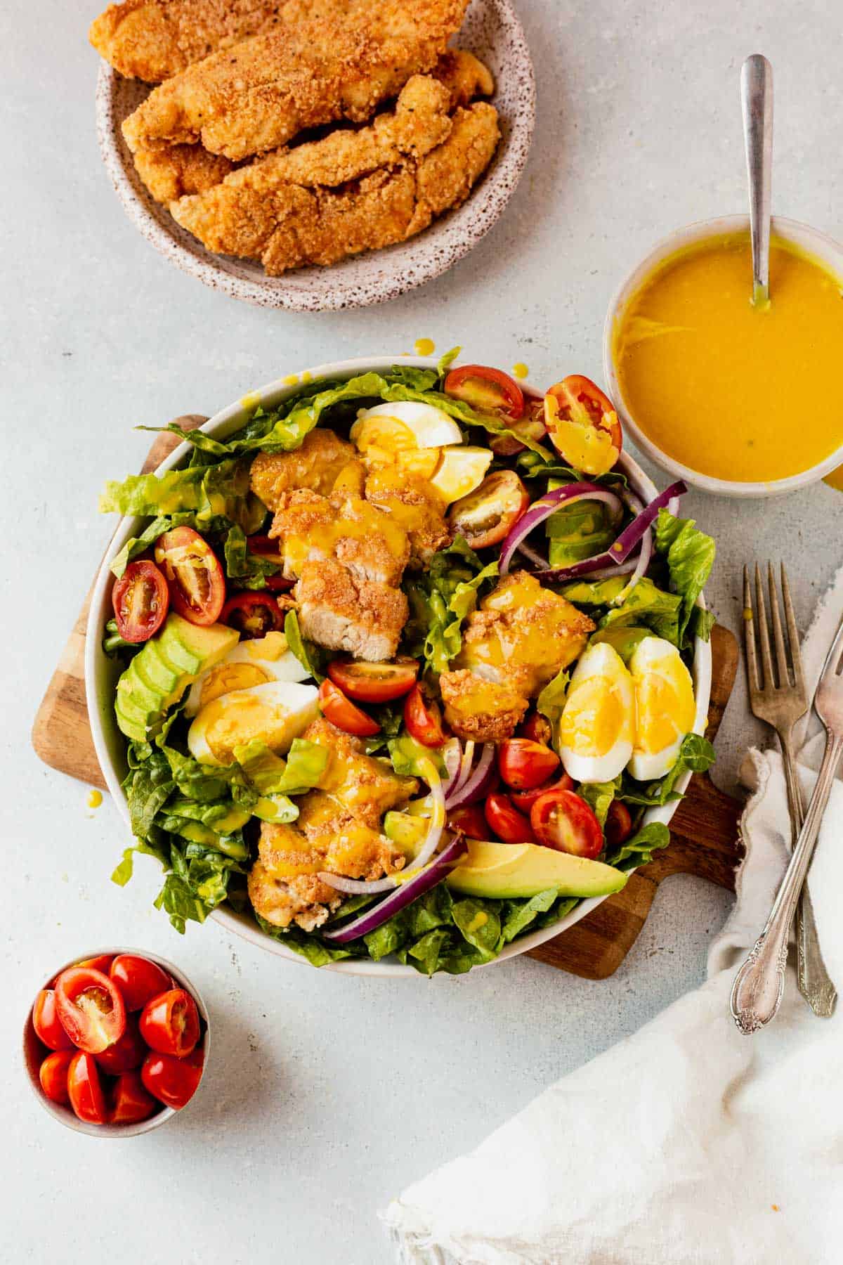 crispy chicken salad in a bowl with honey mustard on the side
