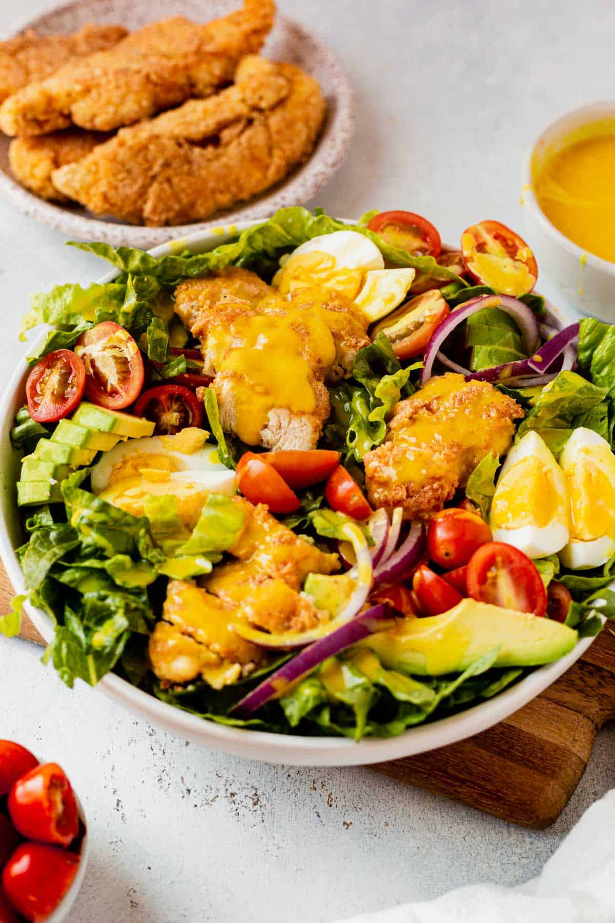 crispy chicken salad with eggs, avocado, and tomatoes