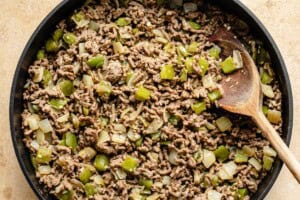 ground beef cooked with onion and peppers in a pan.