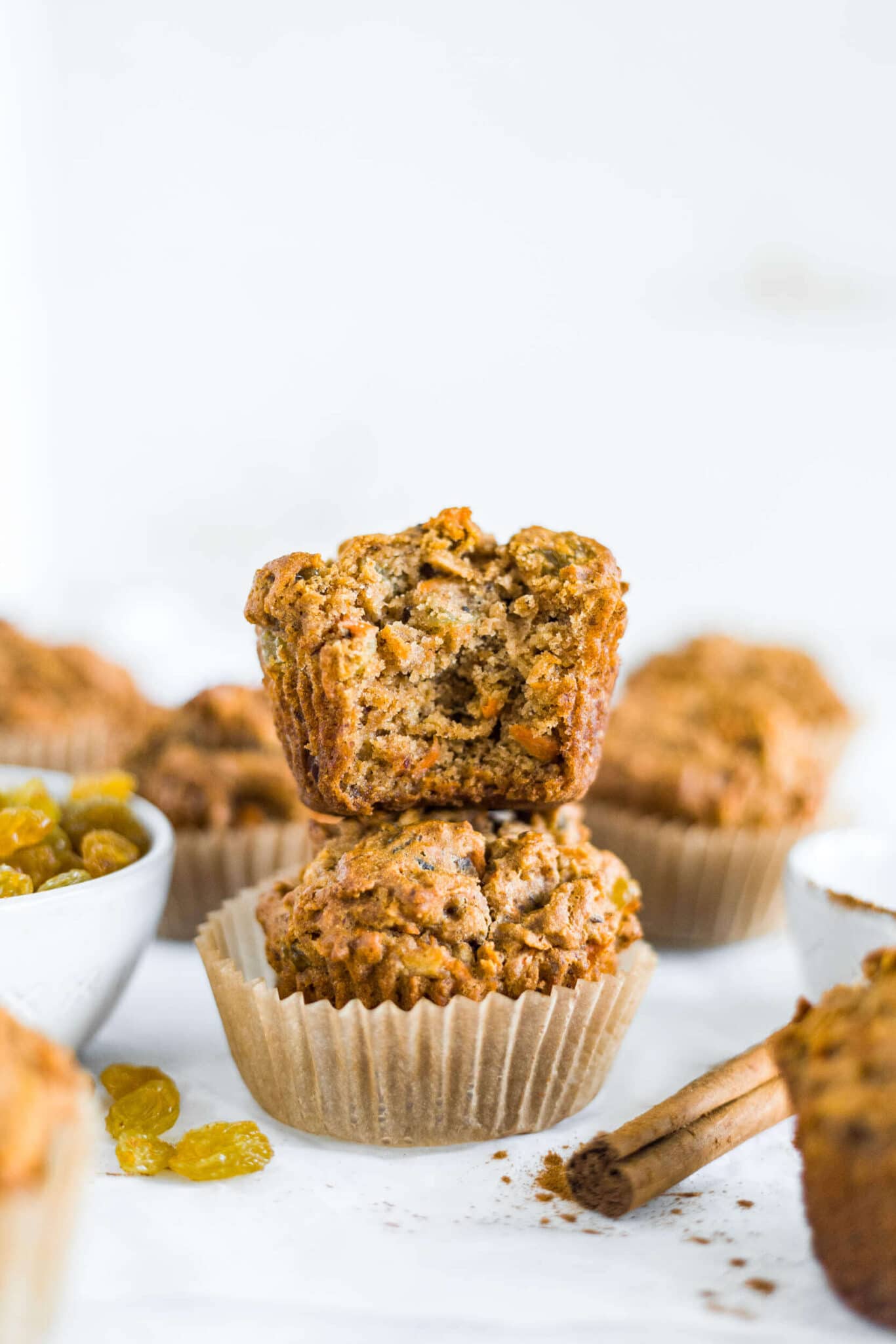 gluten free morning glory muffin stacked on top of another one with a bite taken out