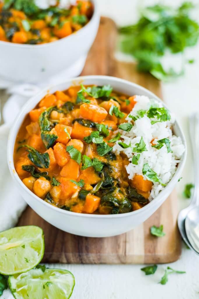 sweet potato red thai curry in a white bowl with white rice and cilantro