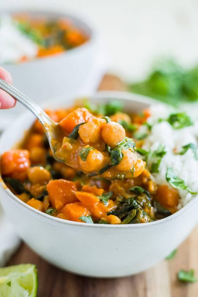 a bowl of creamy sweet potato curry and rice with a spoon