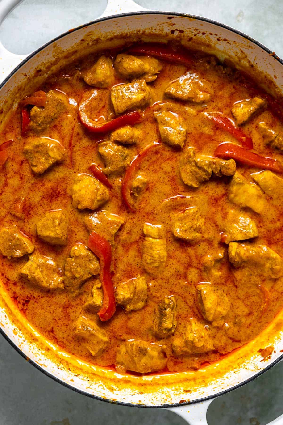 creamy coconut curry chicken simmering on the stove top.