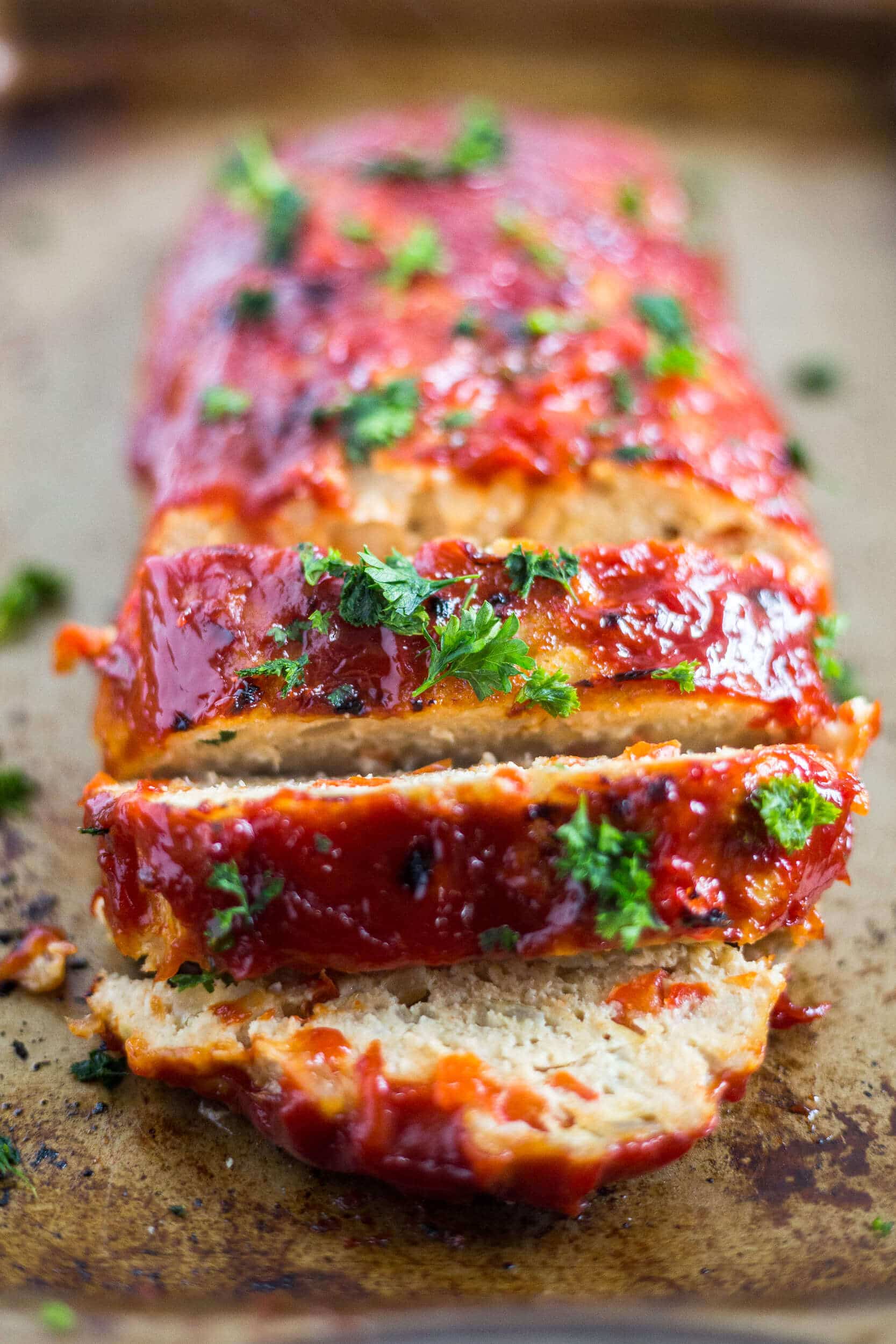 gluten free turkey meatloaf with a ketchup glaze sliced on a baking sheet