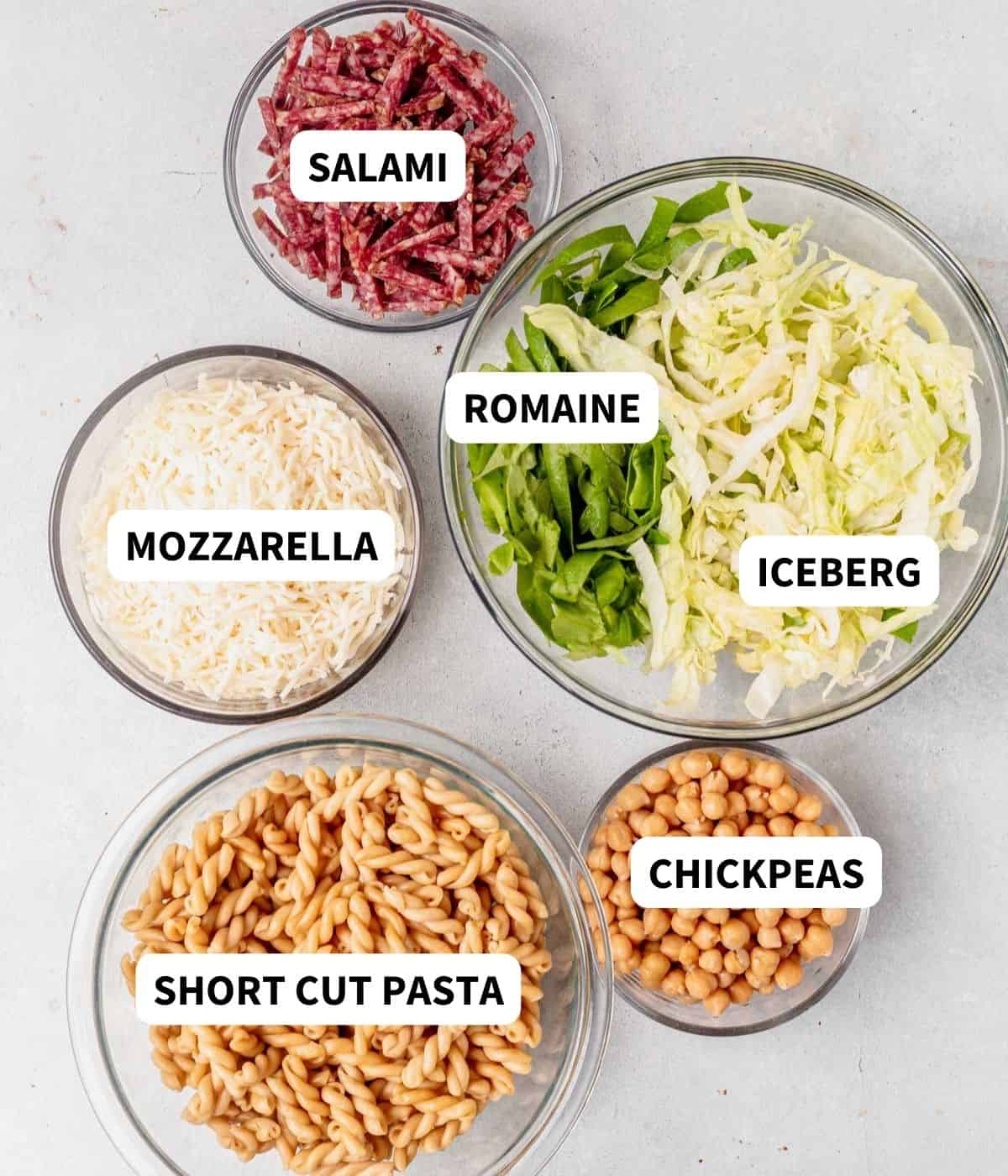 pasta, salami, mozzarella, chickpeas, and lettuce on a countertop