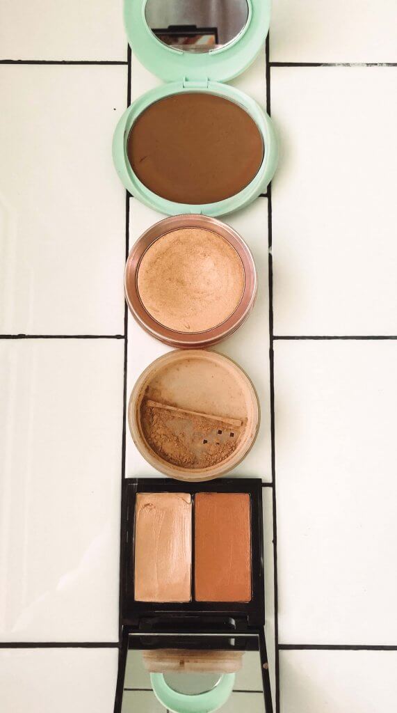 bronzer, blush and highlighter sitting on white subway tile