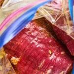 flank steak in pineapple marinade in a plastic bag.